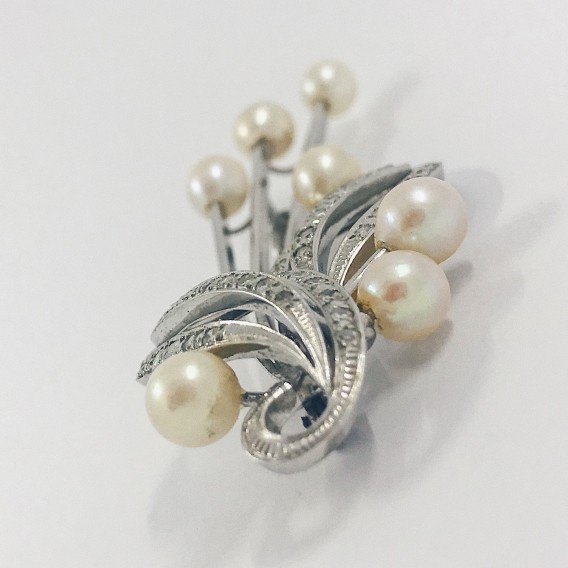 Broche largo en oro blanco con perlas y brillantes.