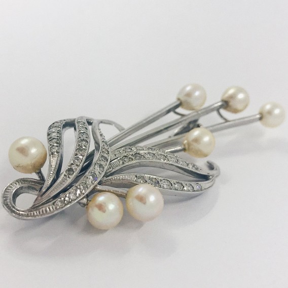 Broche largo en oro blanco con perlas y brillantes.