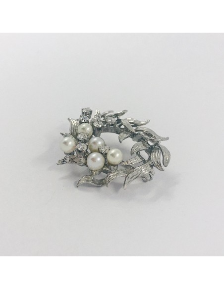 Broche circular en oro blanco con perlas y brillantes.
