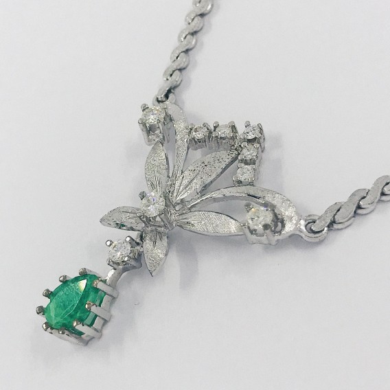 Gargantilla flor en oro blanco con brillantes y esmeralda.